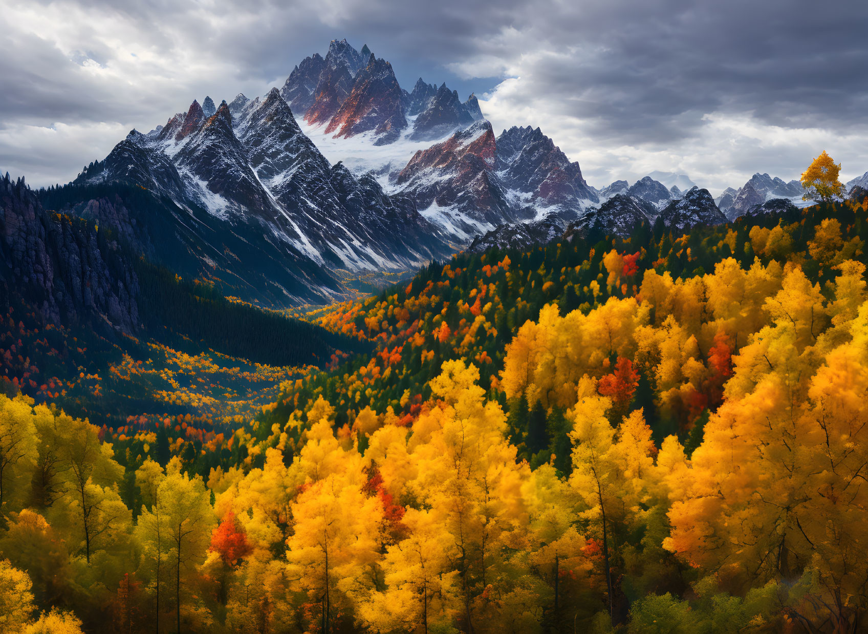 Majestic mountain peaks above vibrant autumn forest and cloudy sky