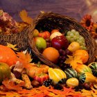 Ornate patterned pumpkins and gourds in wicker basket with autumn leaves