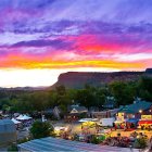 Colorful sunset over mountain town with illuminated buildings