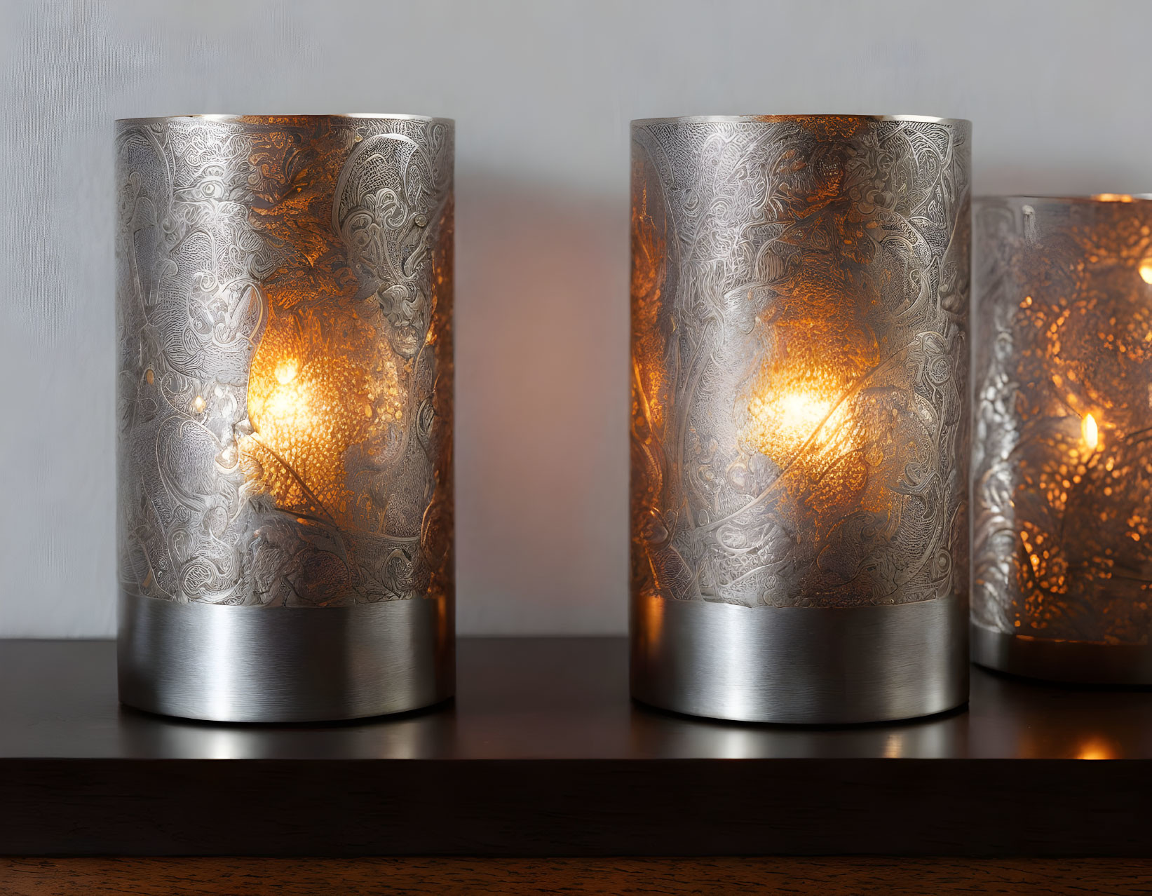 Illuminated metallic patterned lamps on wooden surface casting warm glow