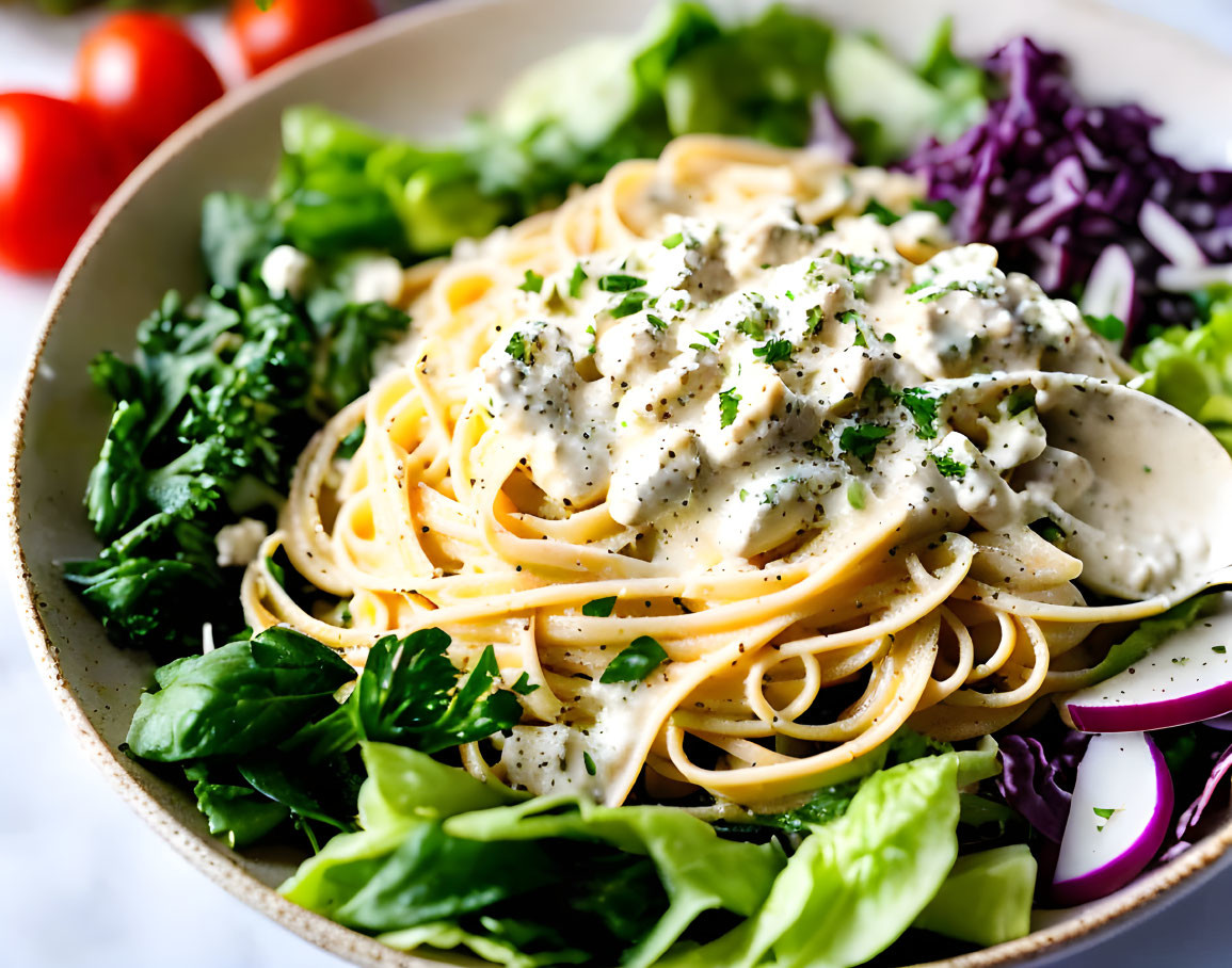 Creamy spaghetti dish with fresh vegetable garnish.