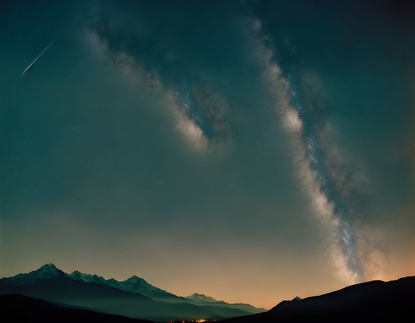 Stunning Milky Way over mountains with meteor streak