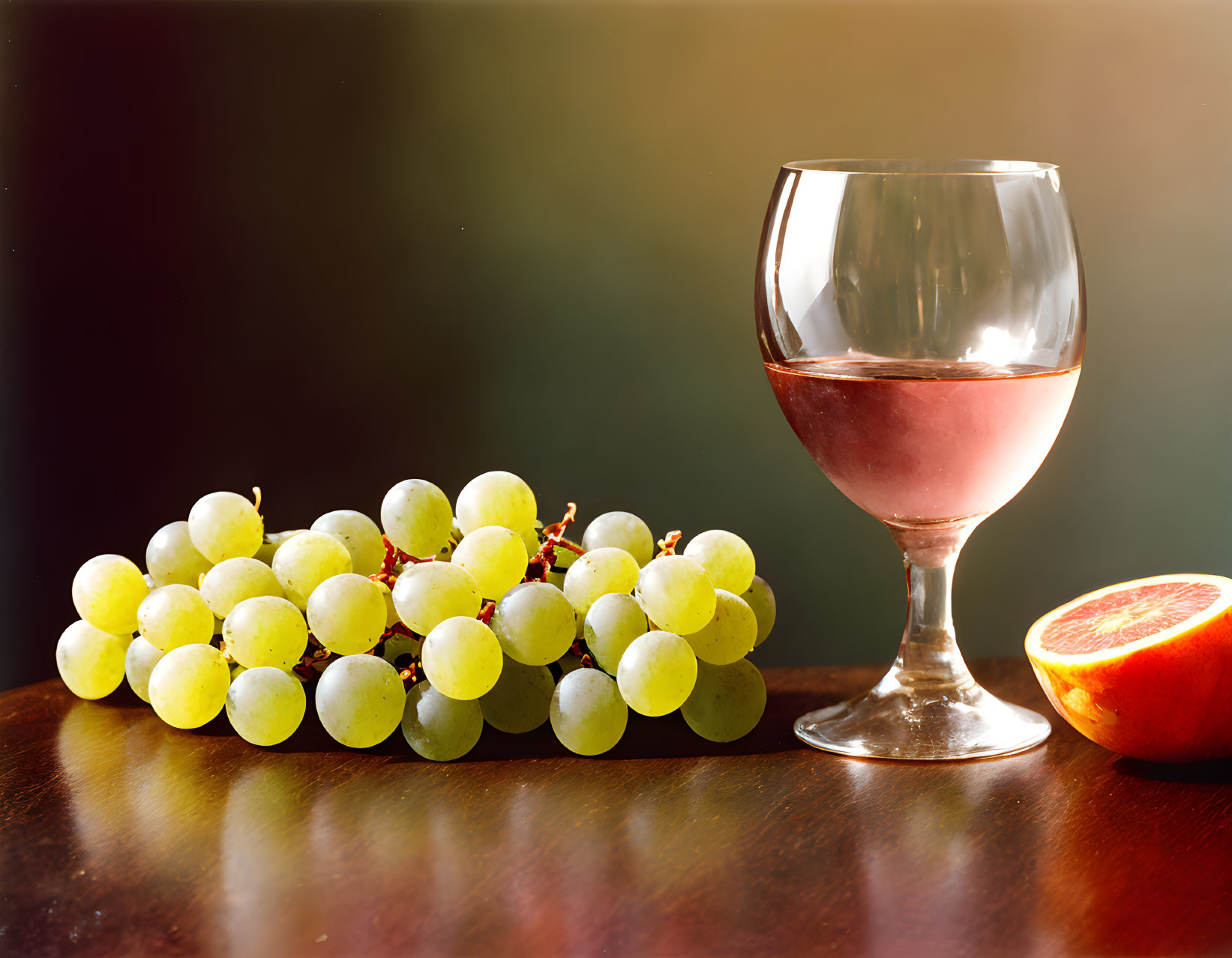 Green grapes, wine glass, and orange slice on dark gradient background