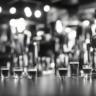 Monochrome humanoid robot at bar with shot glasses and bokeh lights