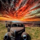 Vintage car on grassy field under red-tinted sky with full moon