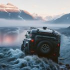 Four-Wheel-Drive Vehicle Crossing Shallow River with Snow-Capped Mountains at Sunset