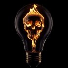 Fiery skull inside light bulb on black background