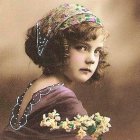 Woman with Flowers in Hair Among White Roses and Greenery