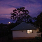 Cozy house illuminated under purple twilight sky