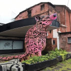 Pink Furry Rodent-like Creature in Greenery with Dilapidated Structure