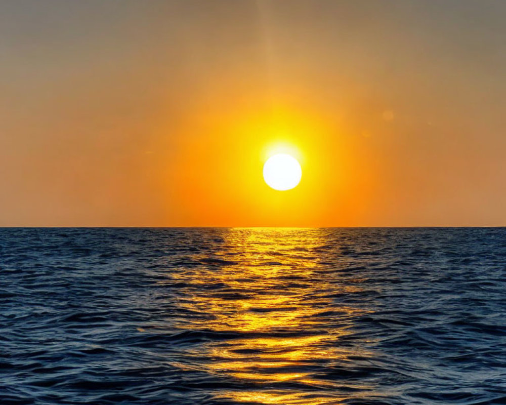 Vivid ocean sunset with sun's reflection on water