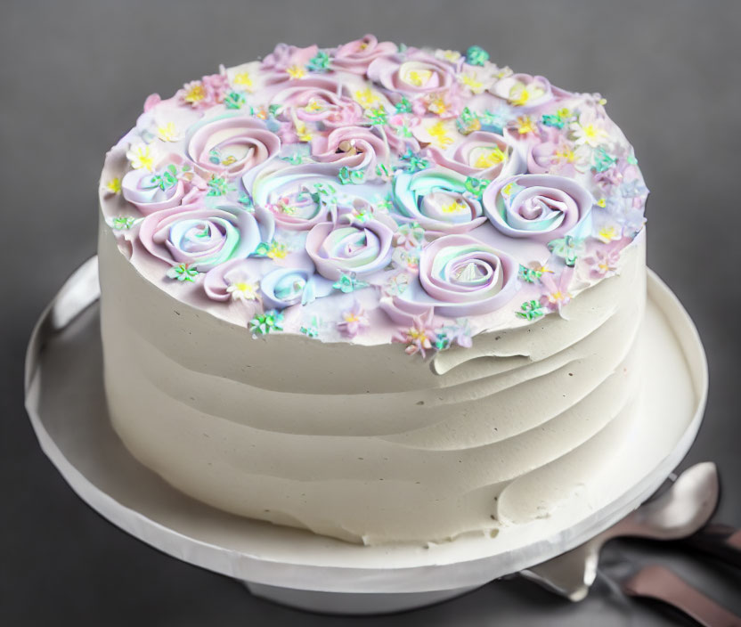 Pastel-colored rose-shaped icing on frosted cake with flower decorations