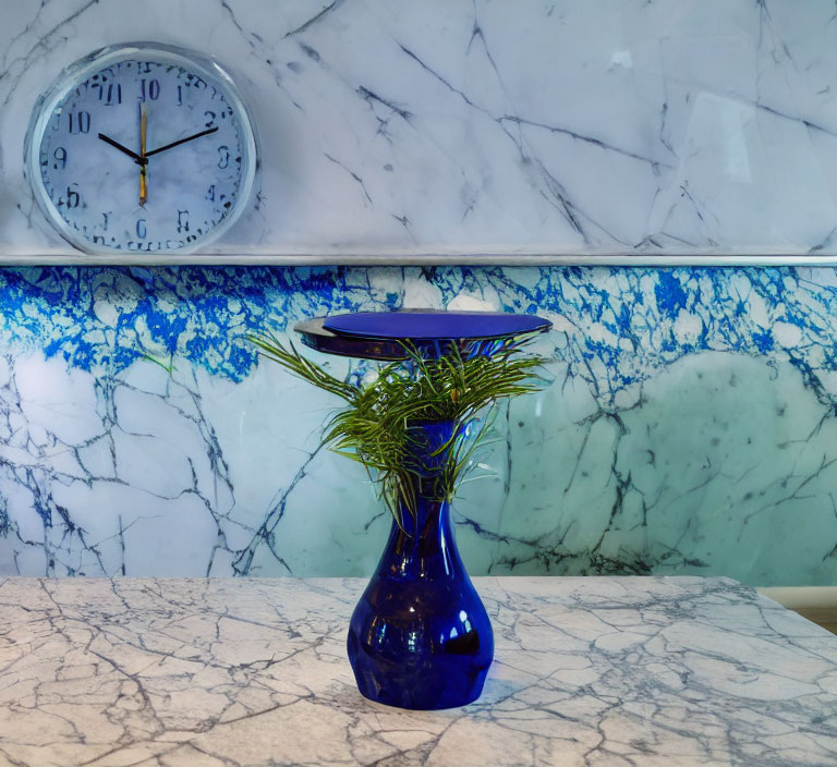 Blue Vase with Green Plants on Marbled Counter and Wall Clock Displaying Time