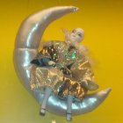 Golden-armored figure on crescent moon in ethereal setting