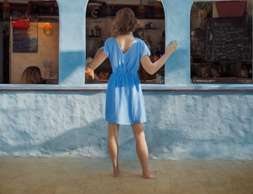 Woman in Blue Dress Standing at Rustic Eatery Counter