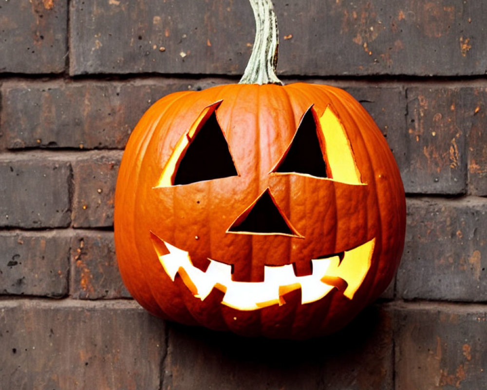 Carved Pumpkin with Jagged Smile and Triangle Eyes on Brick Wall Background