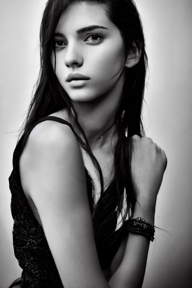 Monochrome portrait: Woman with long hair, dark dress, and bracelet