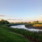 Ancient pyramids by serene river at dusk