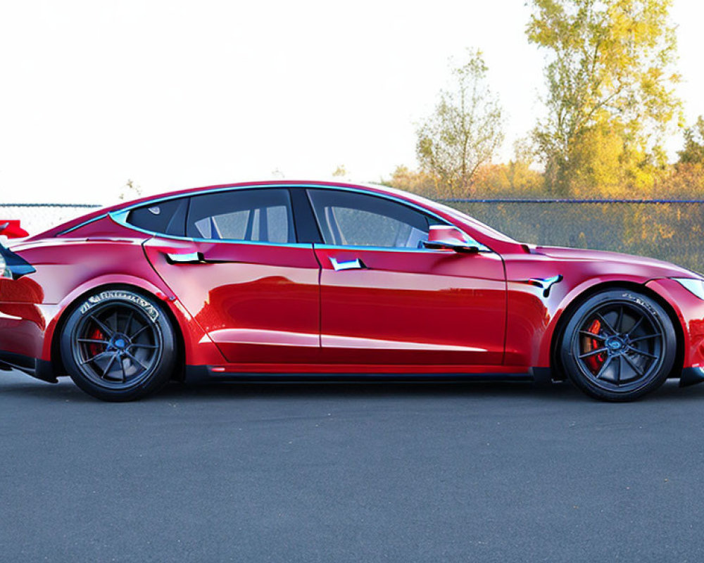 Vibrant red sports sedan with aftermarket modifications on asphalt road