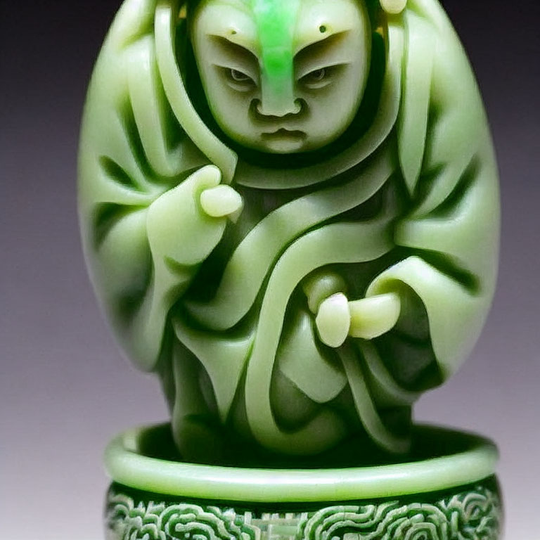 Detailed Green Jade Carving of Figure with Intense Gaze and Elaborate Drapery