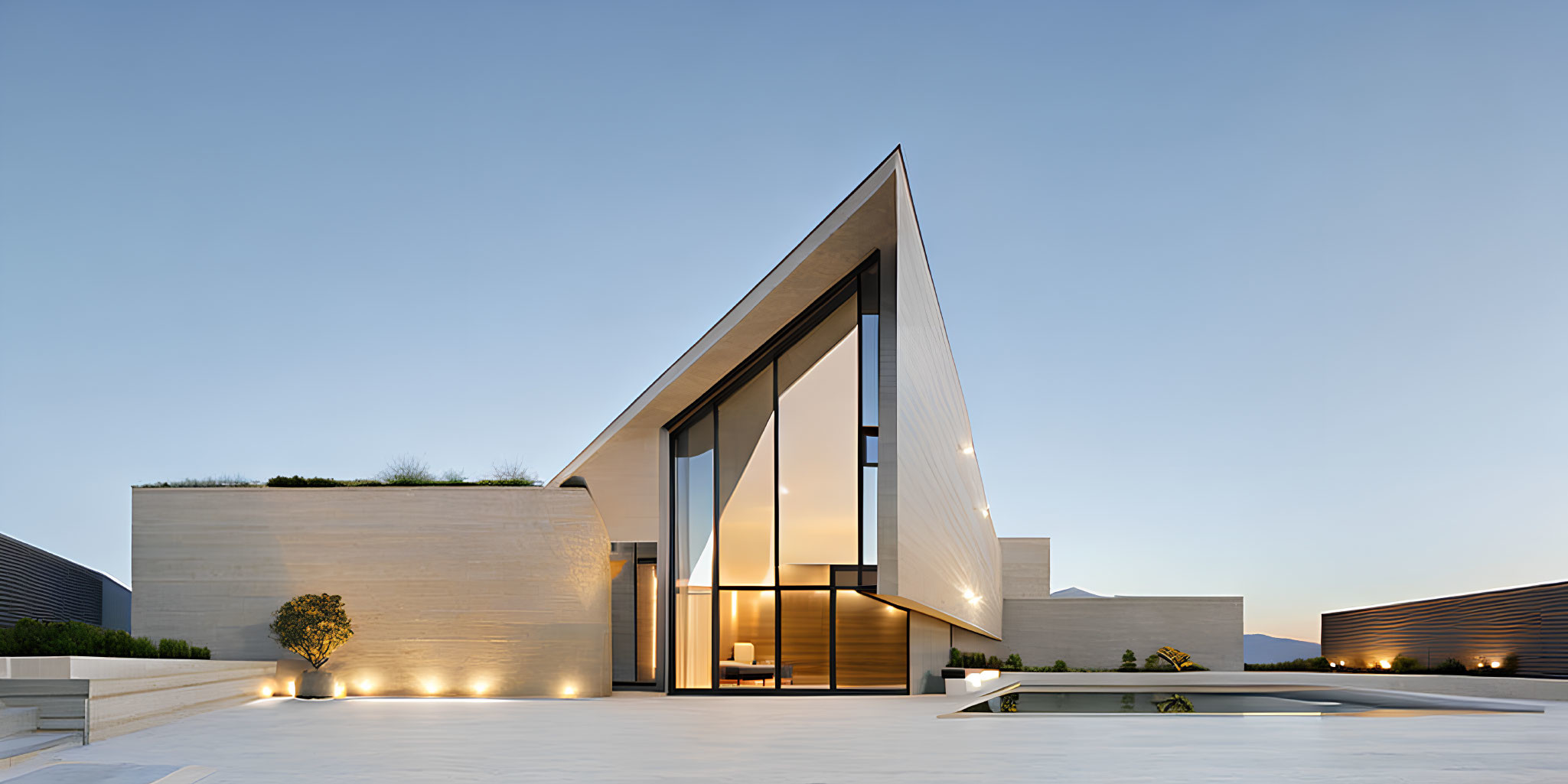 Modern Architectural Home with Triangular Roof and Glass Windows Illuminated at Twilight