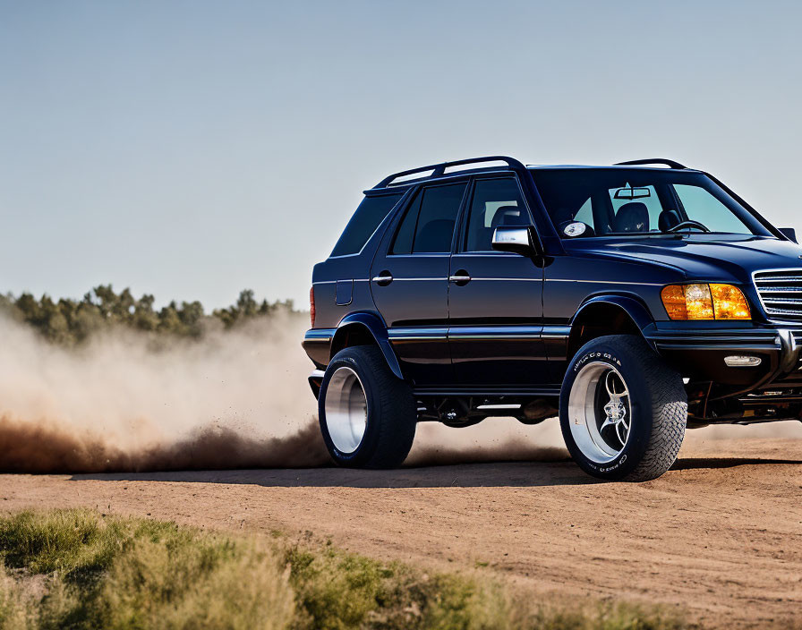 Black SUV on Dirt Road Creating Dust Trail Under Blue Sky