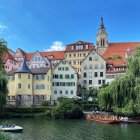 Fantastical riverside town with towering spires and autumn-hued trees