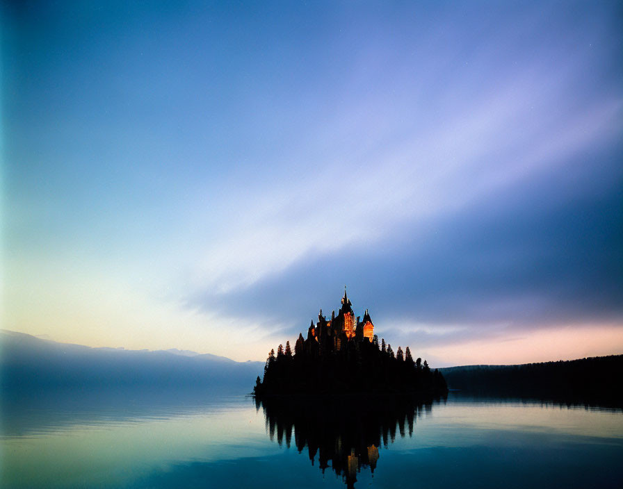 Castle silhouette reflected on calm lake at twilight