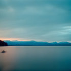 Twilight scene: lone castle reflected in serene water with dramatic sky.