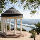 Scenic hilltop gazebo by tranquil lake and lush trees