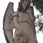 Detailed Angel with Large Wings Holding Rose in Serene Setting