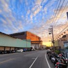 Rusted buildings and derelict vehicles in post-apocalyptic sunset landscape