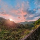 Scenic sunset over mountain landscape with cabins and wildflowers