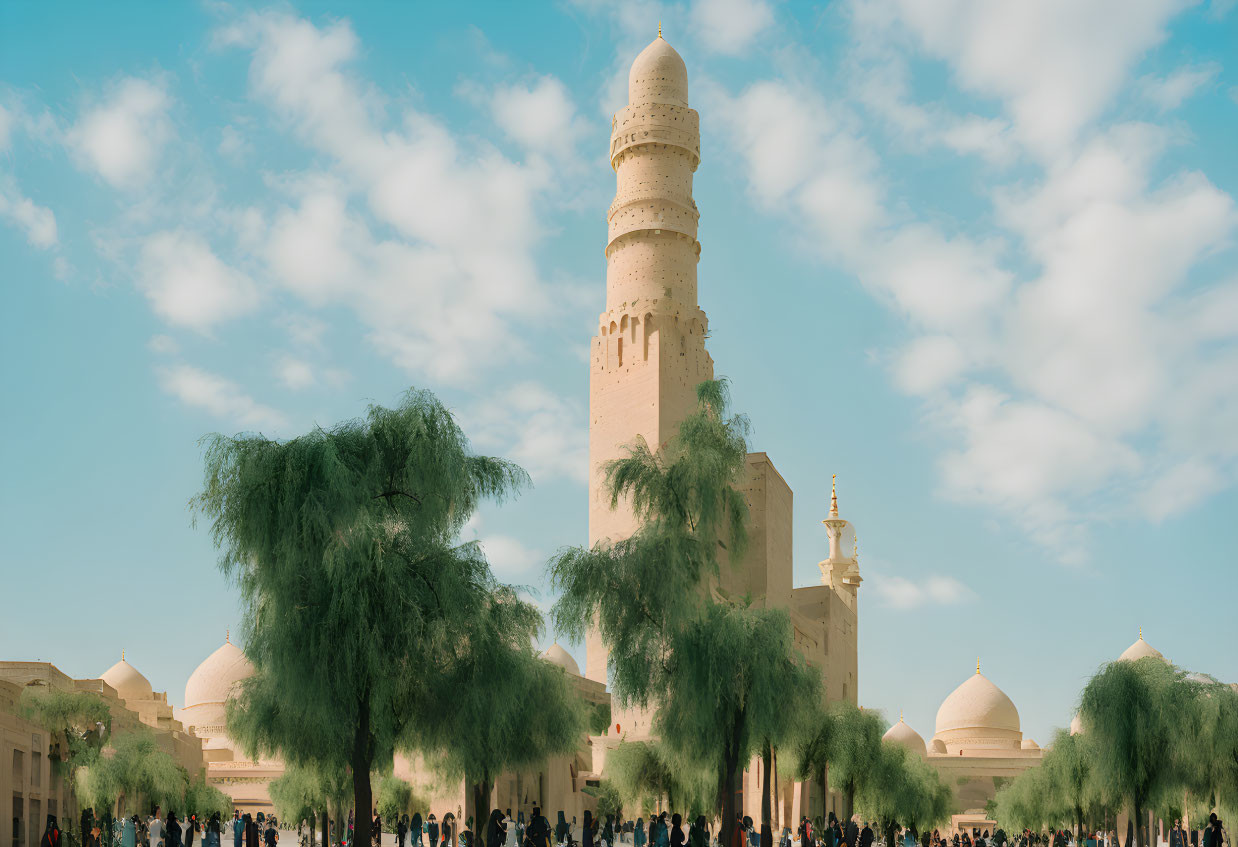 Historic spiraling minaret in mosque complex with crowds and green trees under blue sky.