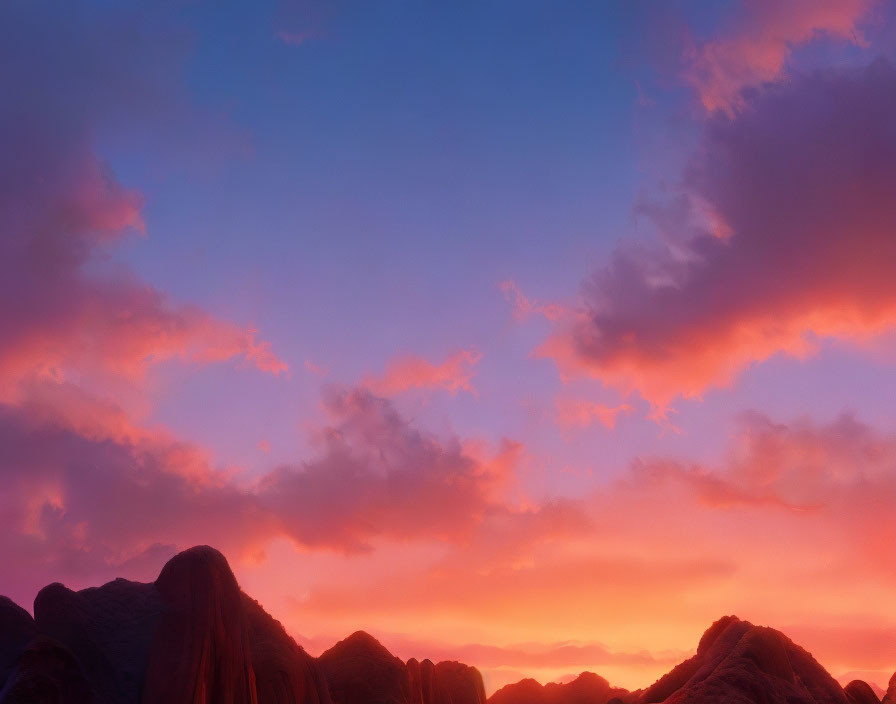 Scenic sunset with pink and orange hues over silhouetted mountains