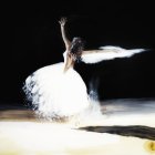 Ballerina in white tutu and blue veil twirling on dark stage