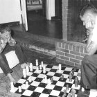 Three children engaged in a game of chess in a focused manner