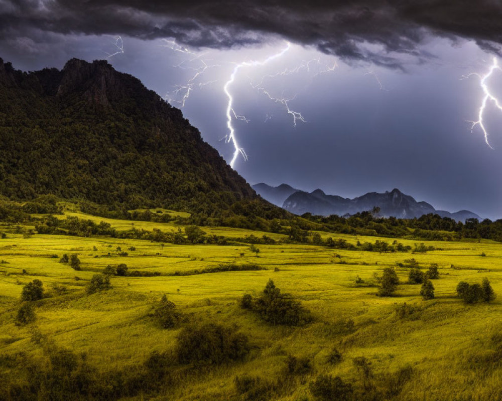 Thunderstorm with Lightning Strikes Over Green Valley and Mountains