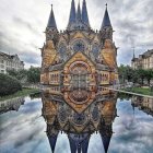 Majestic castle with spires reflected in serene autumnal lake