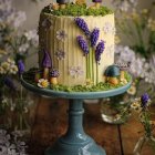 Colorful flower cake with butterfly decoration on blue stand