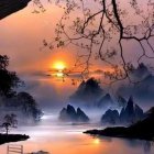 Tranquil sunset over mountainous landscape with lake, silhouetted trees, and mist.