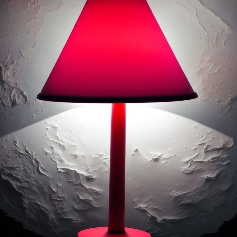 Red Conical Shade Lamp Illuminating Textured White Wall