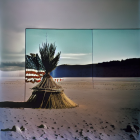 American flag on sticks in barren landscape under moonlit sky with mirror division