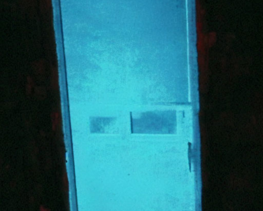 Blue door illuminated in red-lit room exudes mysterious glow