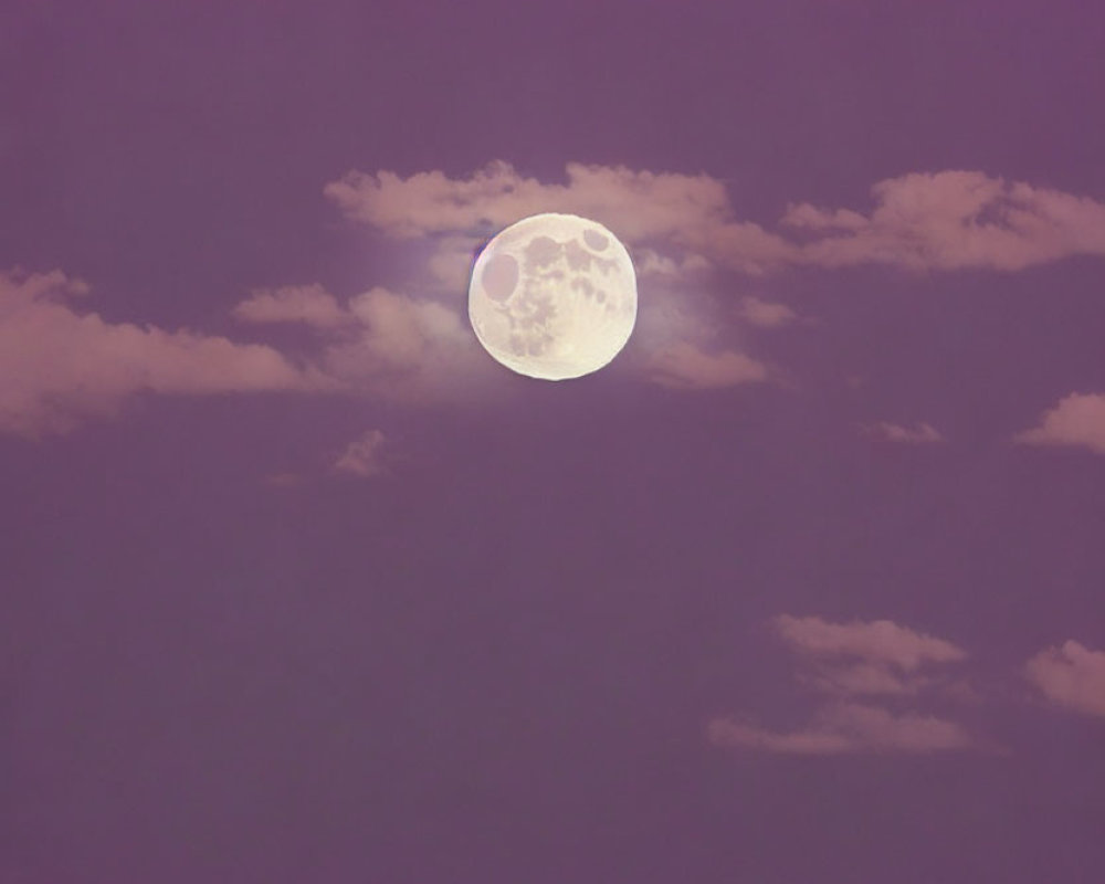 Glowing full moon in purple sky with wispy clouds