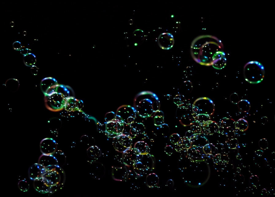 Vibrant soap bubbles on dark background with light reflections