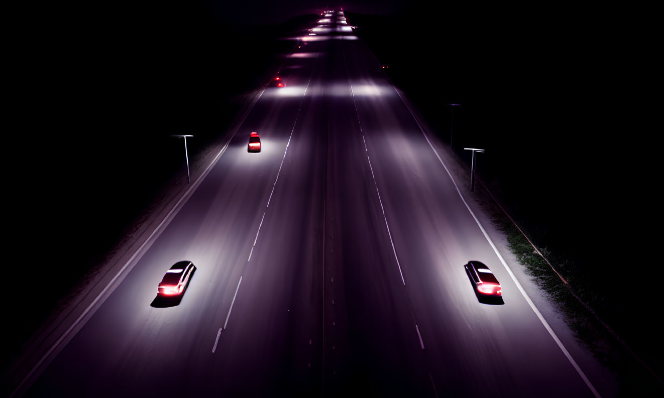 Dark highway at night with glowing red taillights