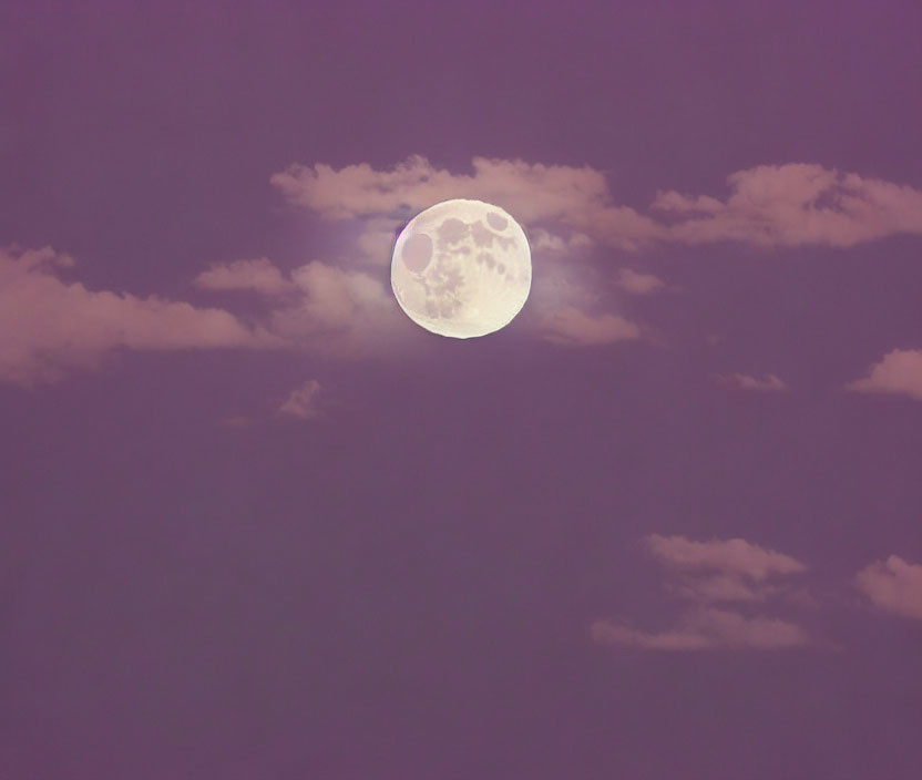 Glowing full moon in purple sky with wispy clouds