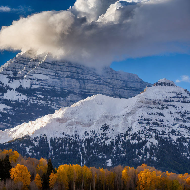 Autumn landscape with snow-capped mountains and dynamic sky