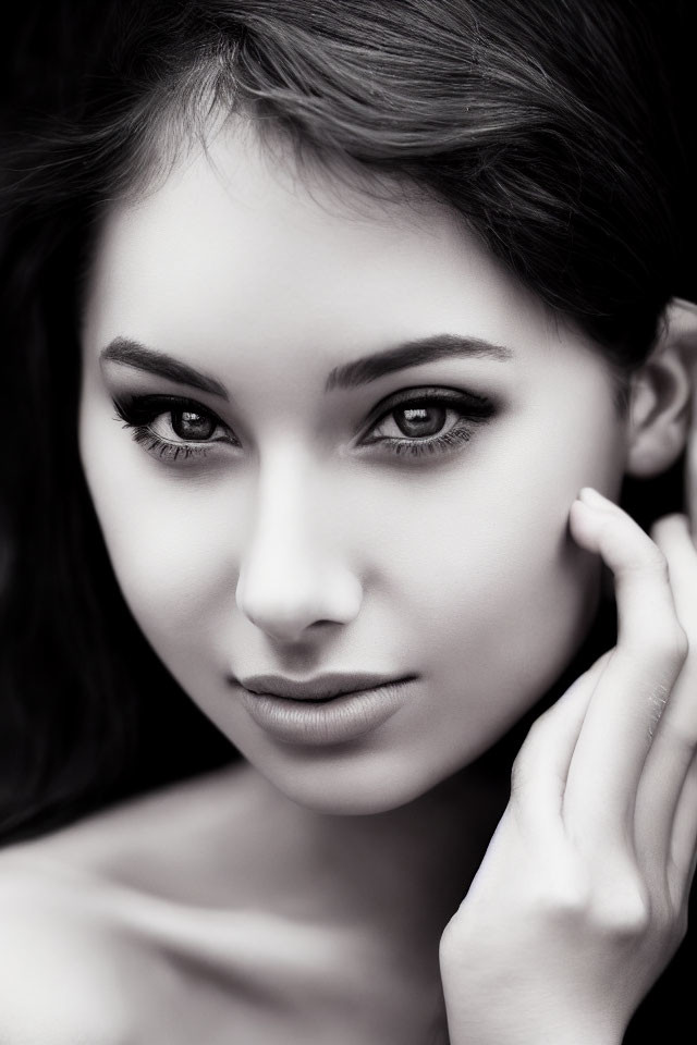 Portrait of woman with dark hair and captivating eyes in monochrome.